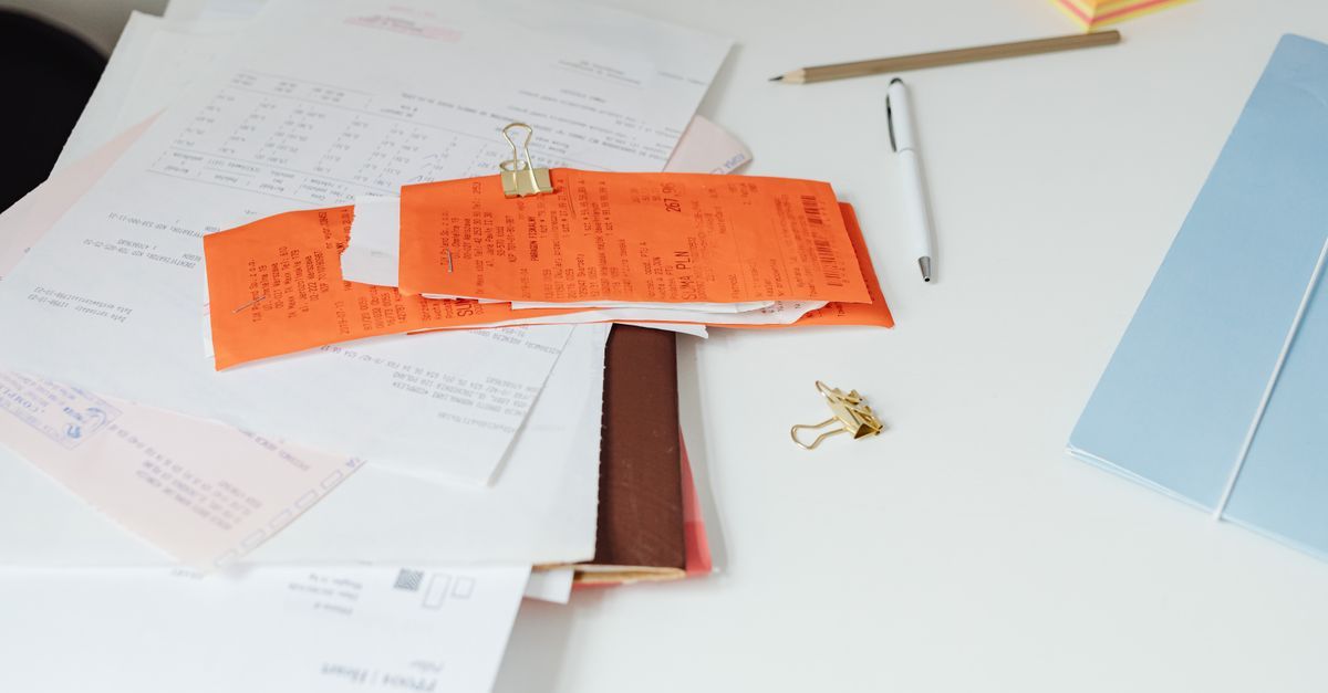 A pile of paper receipts clipped together on a desk