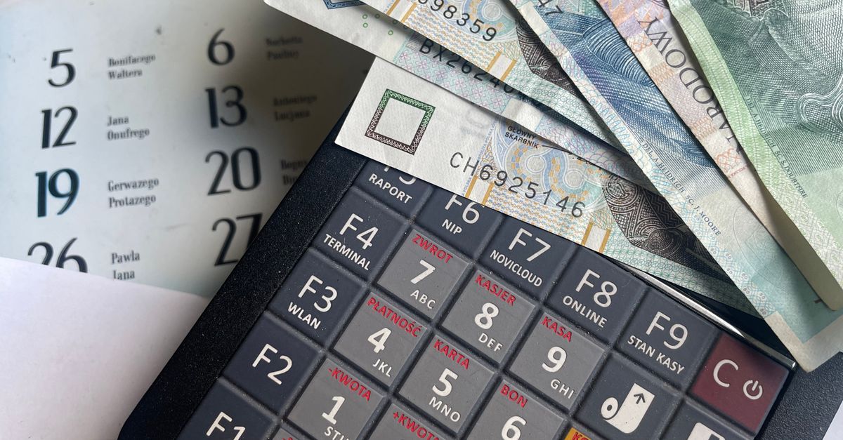 A wall calendar next to a calculator and banknotes